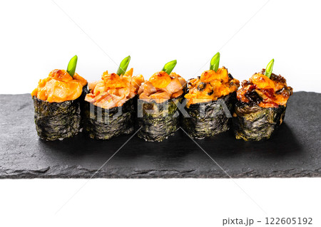 Vulcano lava maki sushi rolls at black stone plate isolated at white background. 122605192