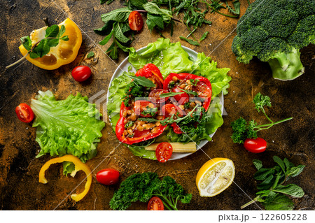 Flatlay plate of fresh vegetarian salad with tomatoes, corn, beans, pepper and parsley at golden textured decorated with vegetables table background. 122605228