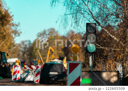 Green light at the traffic light and road repair equipment in the blurred background Green light at the traffic light and road repair equipment in the blurred background 122605509