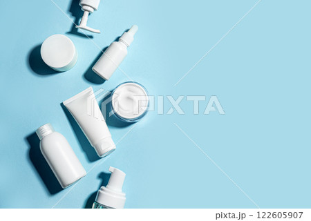White cosmetic containers on blue background White cosmetic containers on blue background 122605907