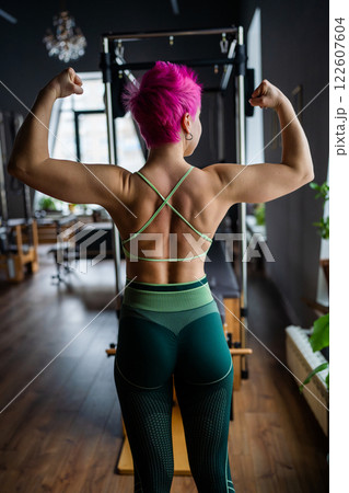 Pilates fitness trainer beautiful back relief. Pilates studio. Young sporty attractive woman wearing sportswear in yoga studio. Fit, healthy and strong authentical body. Fitness concept Pilates fitness trainer beautiful back relief. Pilates studio. Young sporty attractive woman wearing sportswear in yoga studio. Fit, healthy and strong authentical body. Fitness concept 122607604