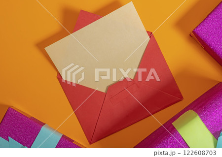 Red envelope containing a letter placed on an orange background surrounded by gift boxes. Red envelope containing a letter placed on an orange background surrounded by gift boxes. 122608703