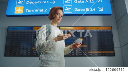 Happy Woman Scanning Plane Ticket Using Smartphone, Smiling, Going to Boarding Flight 122609511