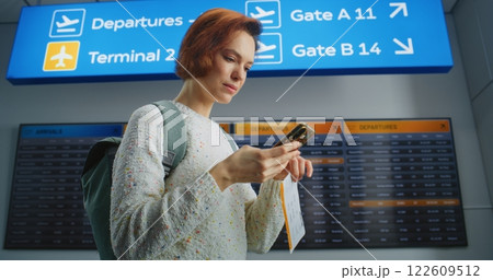 Happy Female Passenger Scanning Plane Ticket Using Phone, Going to Boarding Flight 122609512