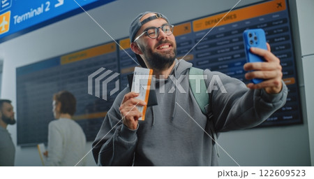 Airport Terminal: Happy Male Passenger Holding Plane Ticket, Taking Selfie Using Smartphone 122609523