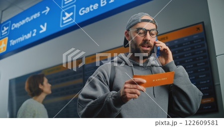 Airport Terminal: Male Passenger Holding Plane Ticket, Talking by Phone 122609581