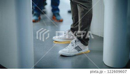 Knee Level Shot of Unrecognizable Passengers Walking Through X-ray Metal Detector Scanning Gates Knee Level Shot of Unrecognizable Passengers Walking Through X-ray Metal Detector Scanning Gates 122609607