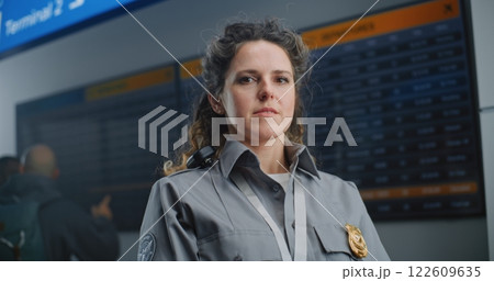 Portrait of Security Officer in Airport Terminal: Female TSA Worker in Uniform Looking at Camera Portrait of Security Officer in Airport Terminal: Female TSA Worker in Uniform Looking at Camera 122609635