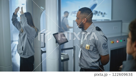 Airport Terminal: Female Security Officer Inspects Young Woman Body for Suspicious Items Airport Terminal: Female Security Officer Inspects Young Woman Body for Suspicious Items 122609638