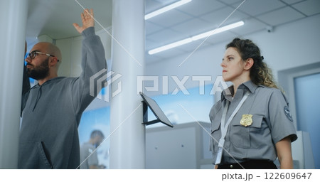 Airport Terminal: Security Officer Inspects Man Body Using Metal Detector Airport Terminal: Security Officer Inspects Man Body Using Metal Detector 122609647
