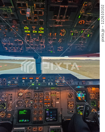 Illuminated cockpit view of an aircraft ready for takeoff at sunrise. High quality photo 122610102