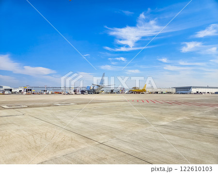Airport tarmac with parked planes under a blue sky with scattered clouds. High quality photo 122610103