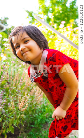 little girl in summer garden posing among flowers little girl in summer garden posing among flowers 122610123