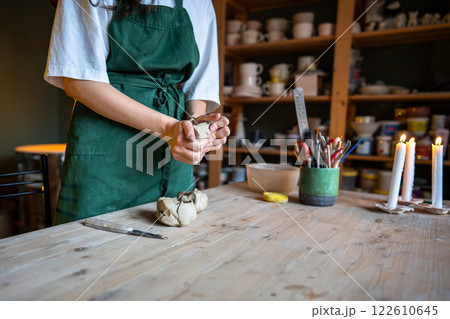 Female potter hands knead clay for craft natural ceramics in workshop. Shape materials in workshop 122610645