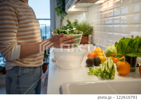 Cooking of quick fresh healthy dinner by prepare of green spinach, celery in hand plastic dryer. Cooking of quick fresh healthy dinner by prepare of green spinach, celery in hand plastic dryer. 122610791
