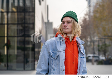 Expressive stylish trendy hipster guy looking like model, freelancer, IT programmer in city street 122610983
