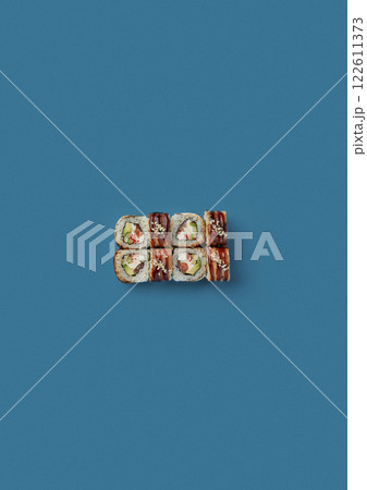 top shot on blue background lies a set of sushi with rice and seafood avocado sushi wrapped in salmon meat red caviar with seaweed professional Japanese cuisine kitchen sushi without shade 122611373