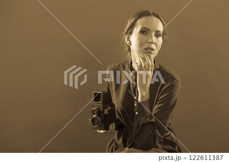 Woman taking picture with old camera Woman taking picture with old camera 122611387