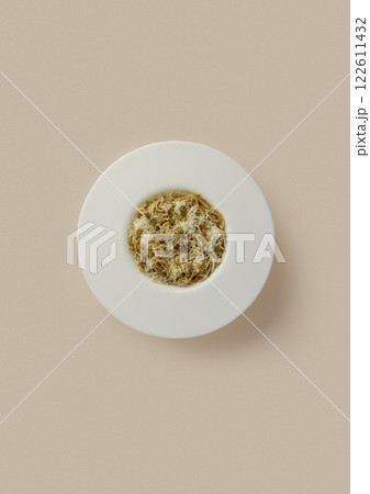 on beige background, a round white plate with Italian pasta with cheese and minced meat. classical cuisine, durum wheat, food rich in carbohydrates and protein. 122611432