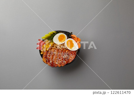 top shot on gray background professional kitchen soup black plate with classic ramen with pork boiled eggs nori sheet corn egg noodles with broth Japanese traditional cuisine 122611470