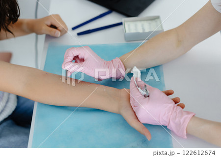Doctor doing skin allergy test at white table in office. Allergy test - skin prick allergy testing for possible allergens Doctor doing skin allergy test at white table in office. Allergy test - skin prick allergy testing for possible allergens 122612674