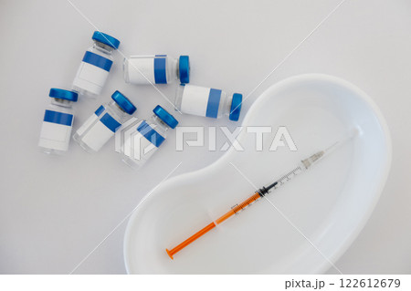 Vials and syringe on white table. Vaccination and immunization for people 122612679