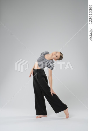 Young girl showcases dance movements in stylish outfit during practice session 122613366