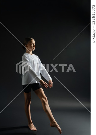 Graceful girl performing expressive dance in casual attire on stage 122613372