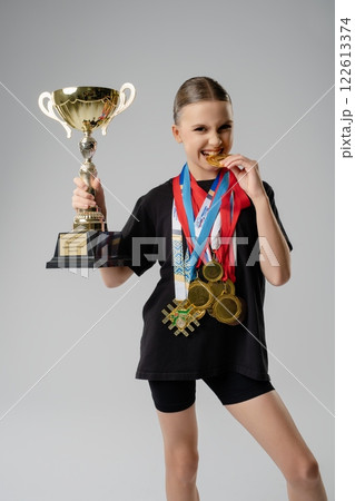 Champion dancer celebrates with trophy and medals after a successful competition Champion dancer celebrates with trophy and medals after a successful competition 122613374