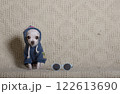 Small dog sitting on a gray background wearing a stylish hooded sweatshirt on his head and looking at the camera. 122613690