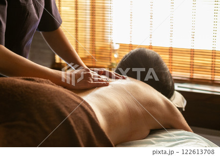 A female masseur massages a woman's back and neck. 122613708