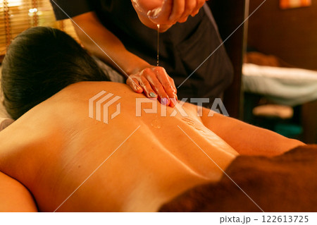 A female masseur massages a woman's back and neck. 122613725