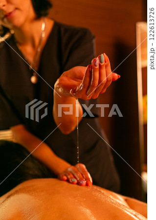 A female masseur massages a woman's back and neck. 122613726