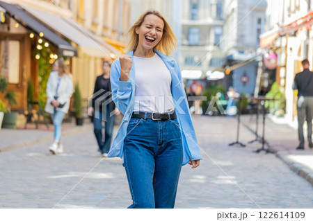 Excited happy woman tourist shouts celebrating success winning triumph career achievement good news Excited happy woman tourist shouts celebrating success winning triumph career achievement good news 122614109