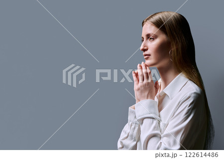 Profile view, serious young woman, copy space gray studio background Profile view, serious young woman, copy space gray studio background 122614486