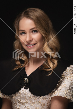 Beautiful blonde in a dress, portrait on a black Beautiful blonde in a dress, portrait on a black 122614518
