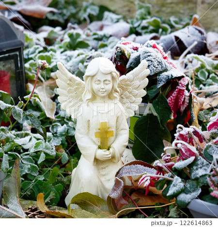 white figure of an angel with a cross in folded hands 122614863