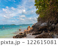 Serene Beach Landscape with Clear Water, Rocks, and Kayakers Under Bright Blue Sky 122615081