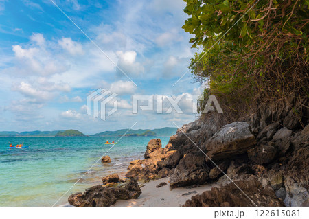 Serene Beach Landscape with Clear Water, Rocks, and Kayakers Under Bright Blue Sky Serene Beach Landscape with Clear Water, Rocks, and Kayakers Under Bright Blue Sky 122615081