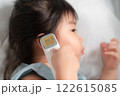 Young Asian Girl with Fever Being Checked by Digital Thermometer in Home Setting 122615085