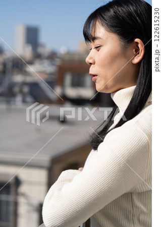 マンションのベランダに立つ若い女性 122615230