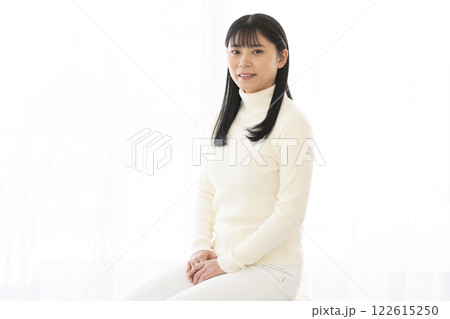 椅子に座ってカメラ目線で微笑む女性 122615250