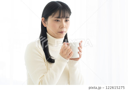 マグカップでホットドリンクを飲む女性 122615275