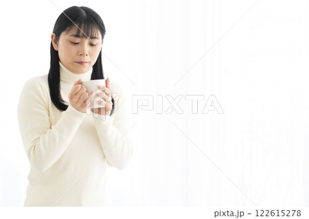 マグカップでホットドリンクを飲む女性 122615278