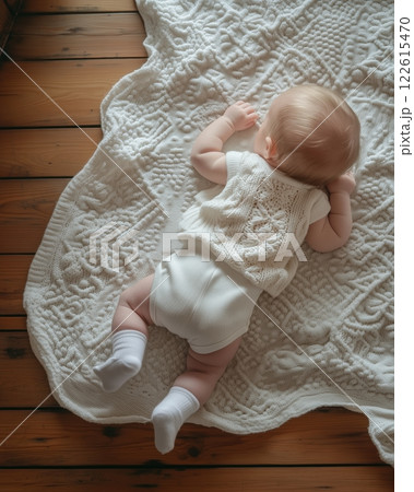 Warm and serene moment with a six month old baby on an antique wood floor with white cotton blanket Warm and serene moment with a six month old baby on an antique wood floor with white cotton blanket 122615470