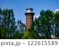 the historic helios lighthouse behind trees and against a blue sk 122615589