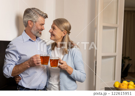 Mature retired couple relaxing at kitchen table drinking tea enjoying morning routine 122615951