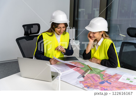 Two female engineers looking involved and excited while working together on the project Two female engineers looking involved and excited while working together on the project 122616167