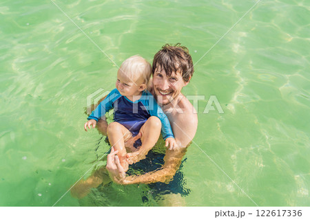 Father with his toddler son swimming in the turquoise waters of Lake Bacalar. Family bonding, summer vacation, and outdoor fun in Quintana Roo, Mexico concept Father with his toddler son swimming in the turquoise waters of Lake Bacalar. Family bonding, summer vacation, and outdoor fun in Quintana Roo, Mexico concept 122617336