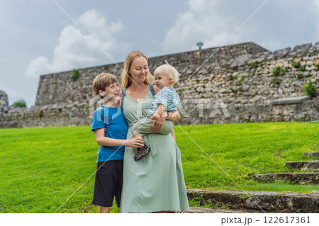 Mother with her toddler and teenage sons exploring Fuerte de San Felipe de Bacalar. Family travel, cultural heritage, and historical adventure concept 122617361